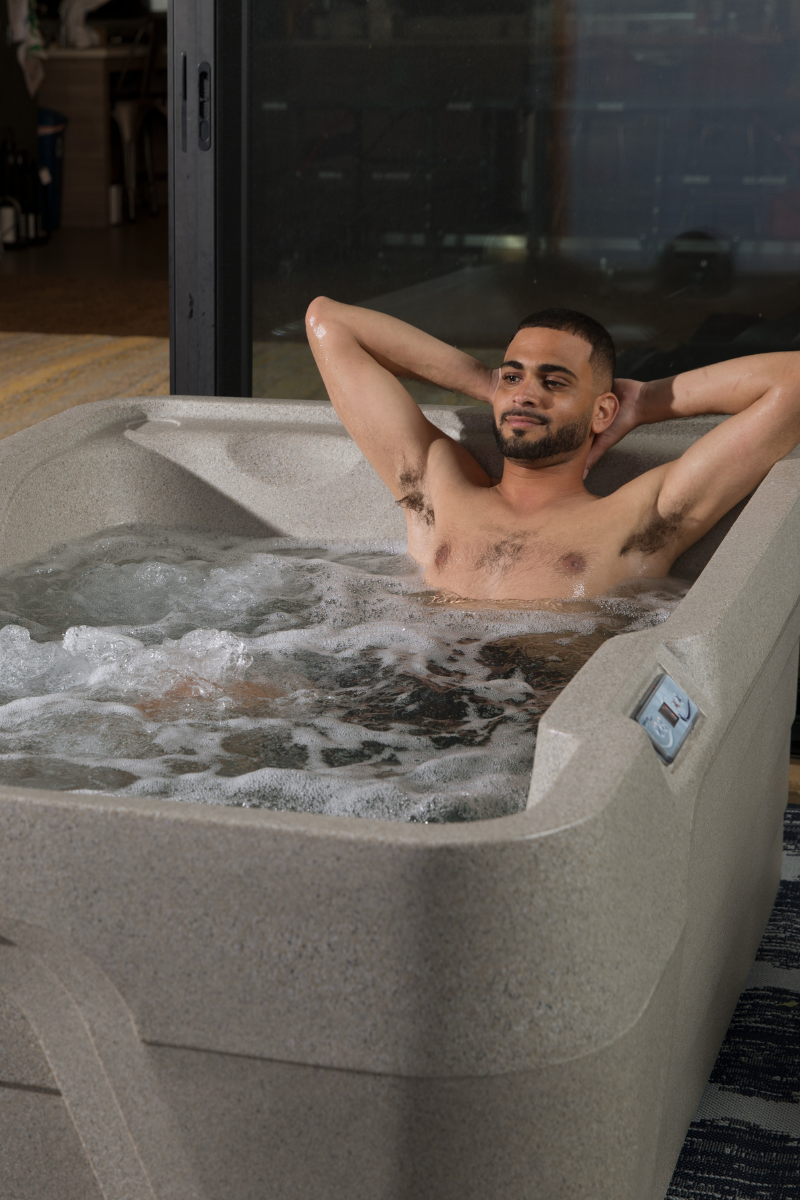 athlete recovering his muscles in a freeflow hot tub after a work out